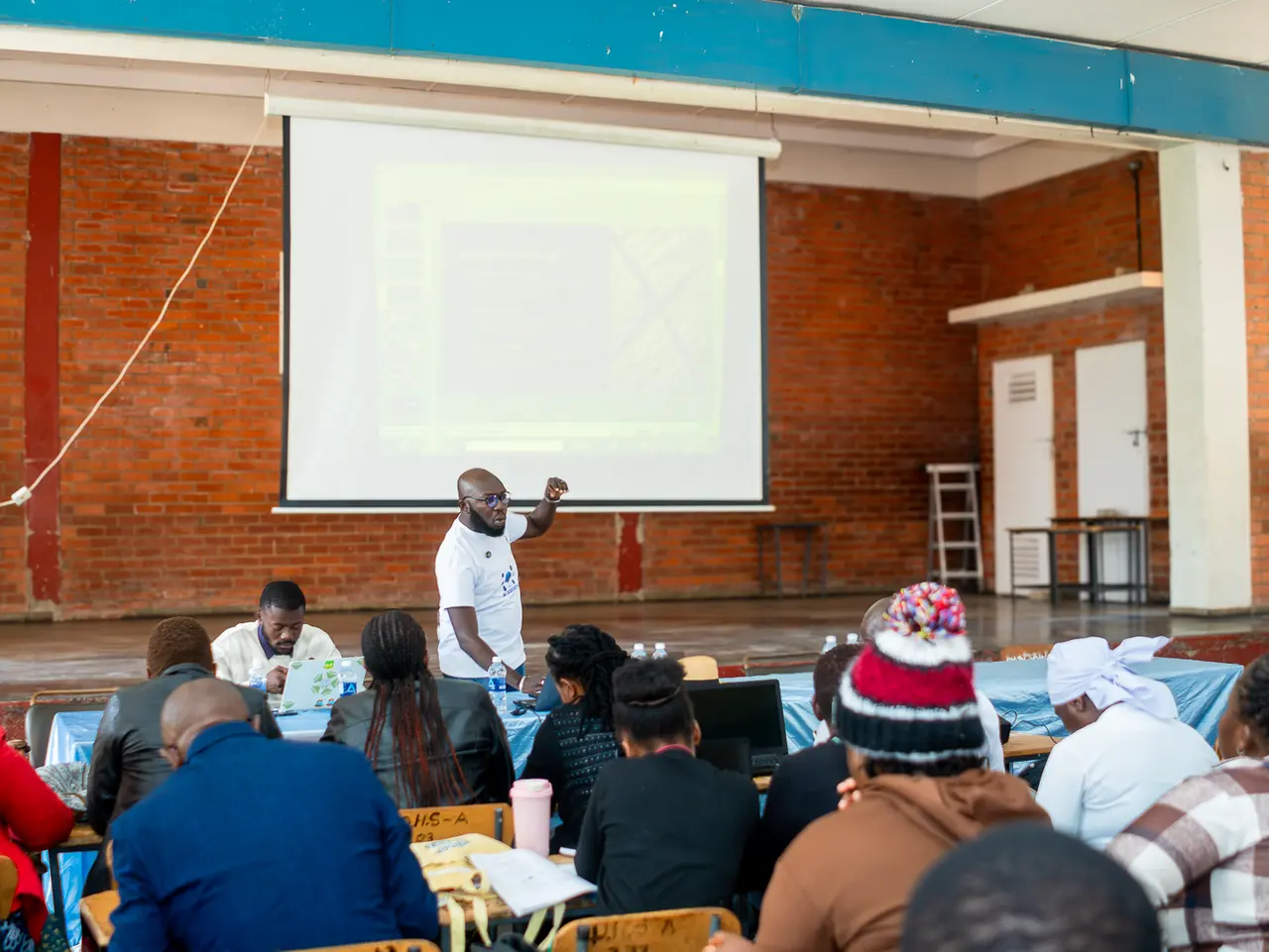 A facilitator in a white shirt presenting to participants at the Mutare workshop